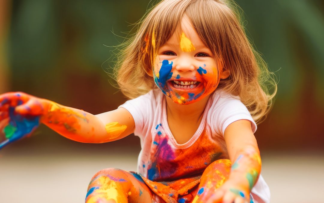 Happy child making a mess with paint